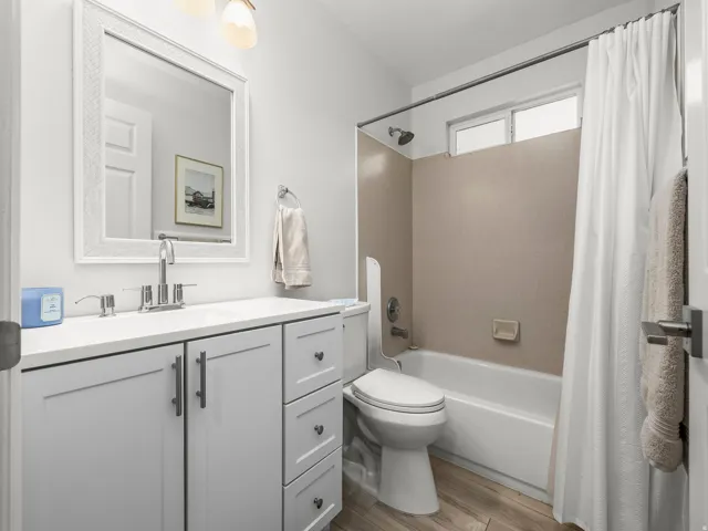 Bathroom featuring a single vanity with gray cabinetry, white countertop, and chrome fixtures