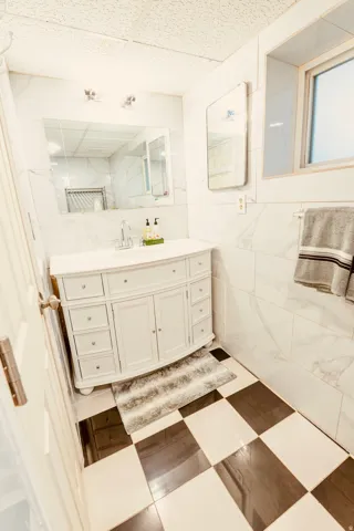 Bathroom featuring a white vanity with integrated sink, chrome faucet, and storage cabinetry