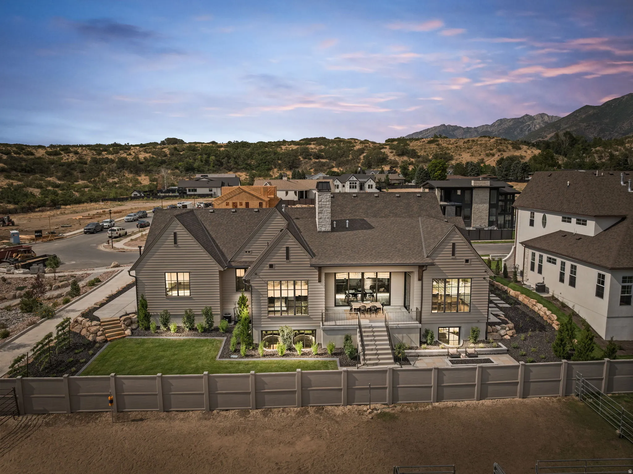 Rear exterior showcasing multiple gables, extensive window placement, and a covered patio with direct stair access to the lower level
