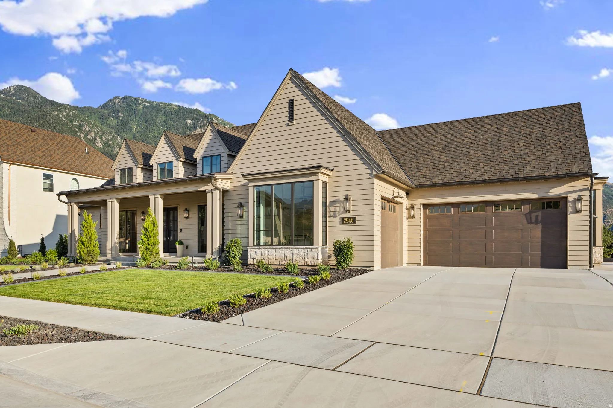 Contemporary residence featuring light tan siding and a dark brown shingled roof