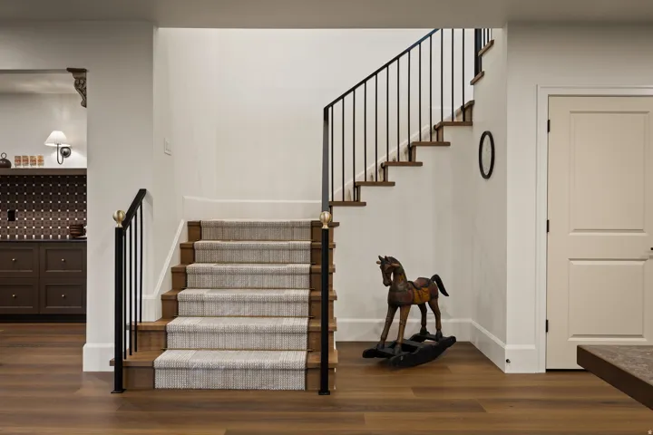 Wood-finish flooring throughout, featuring a carpeted staircase with wood treads and risers