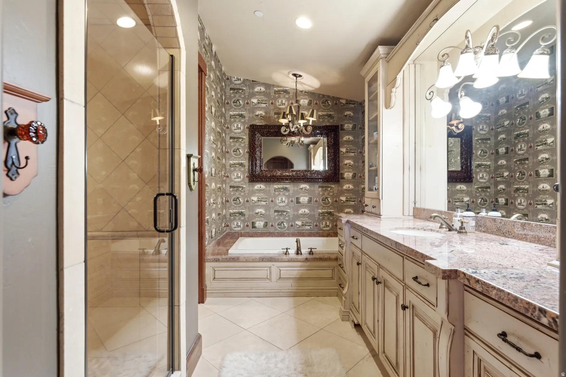 Bathroom featuring a dual vanity with a stone countertop, an undermount sink, and custom cabinetry