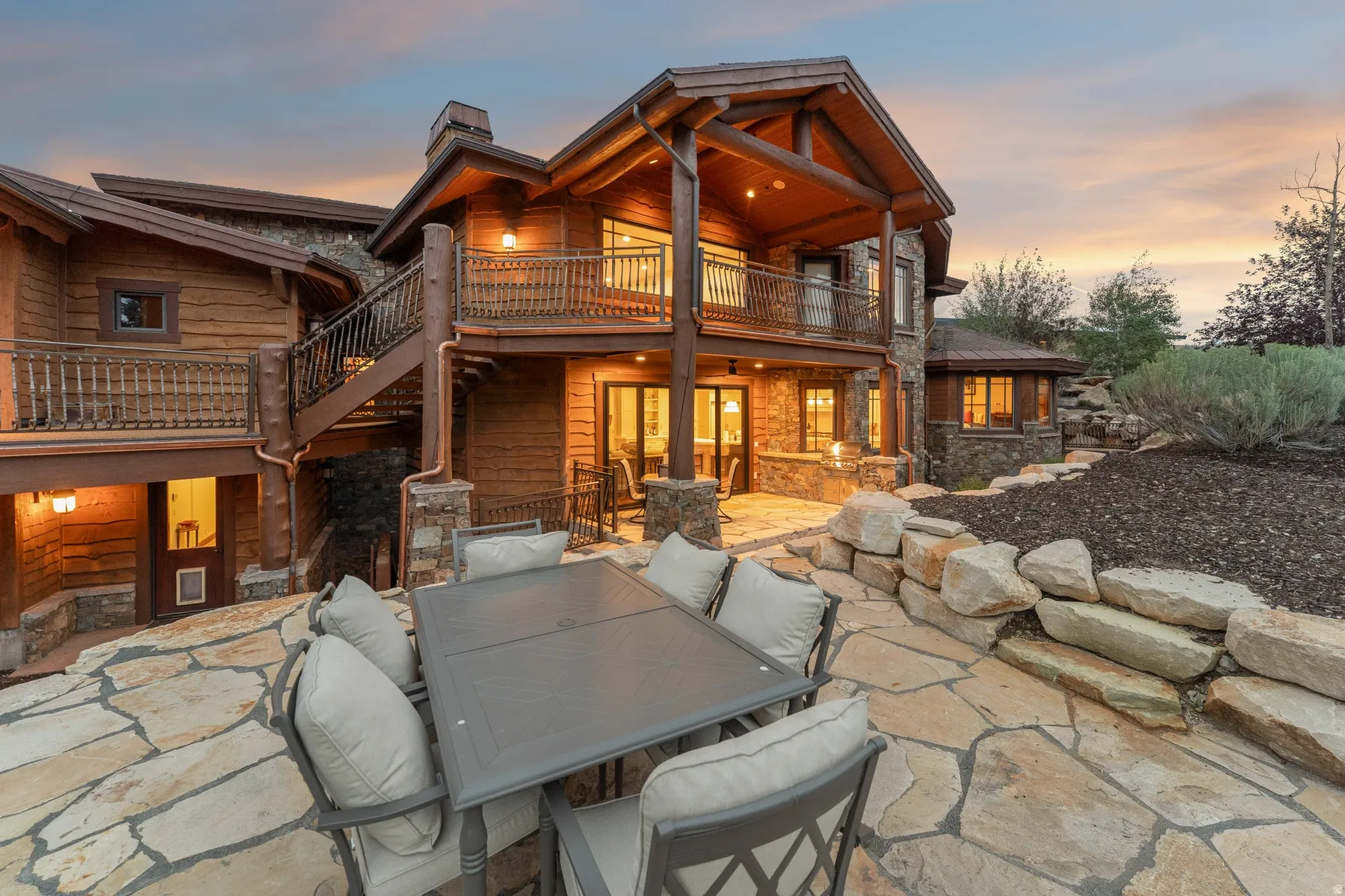 Expansive flagstone patio area featuring a natural stone retaining wall