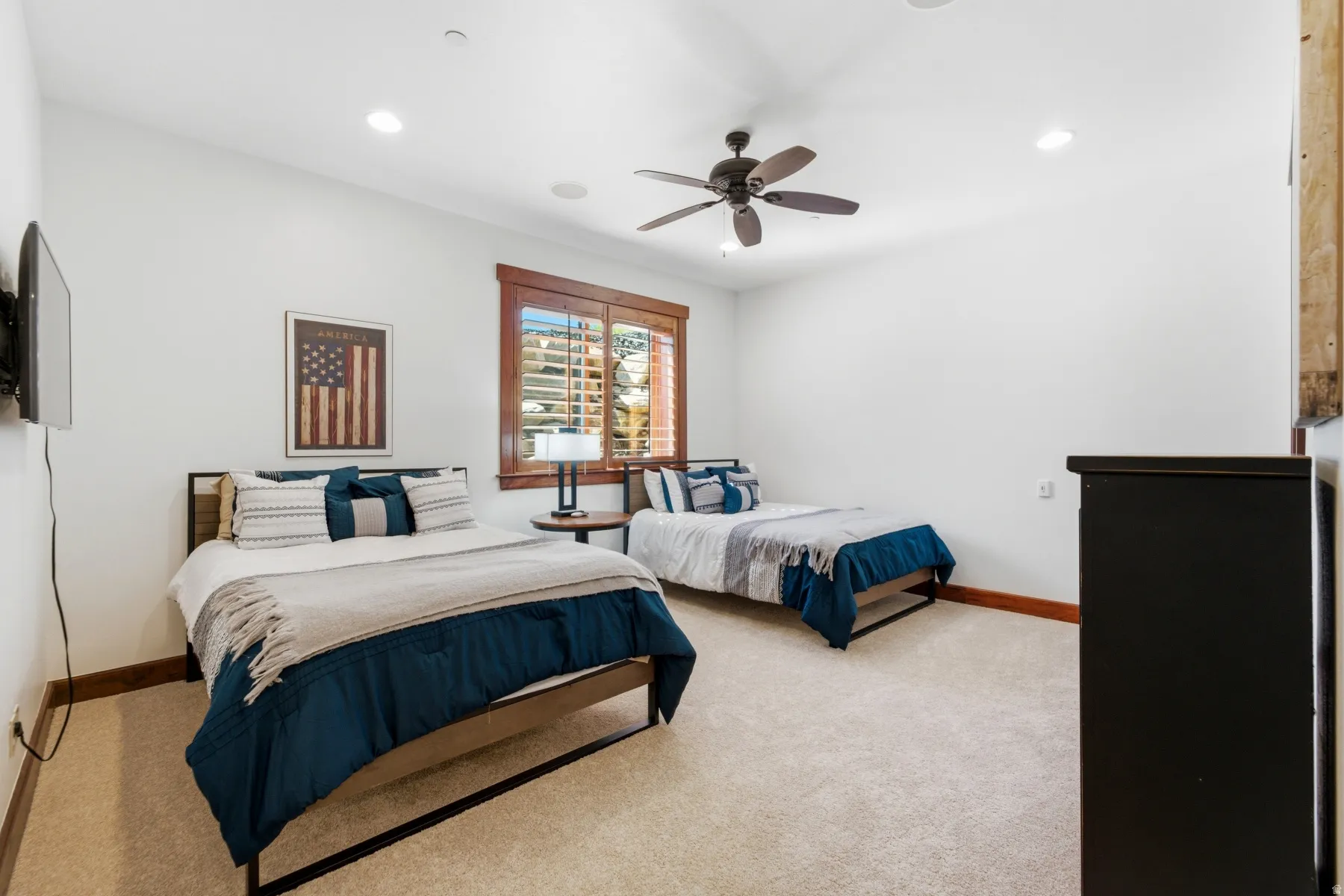 Carpeted room featuring a ceiling fan, recessed lighting, and a window with wood blinds and trim