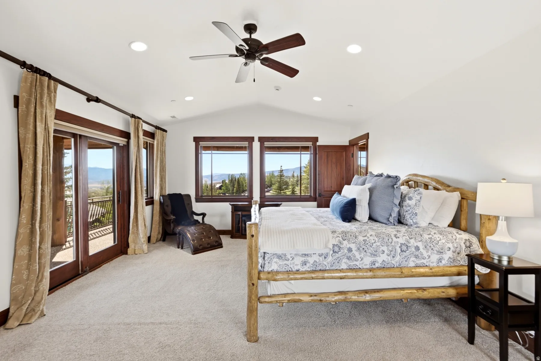 Spacious room featuring vaulted ceilings, recessed lighting, a ceiling fan, and light-toned carpeting