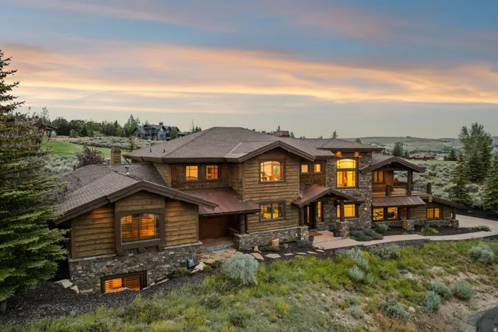 Multi-level home featuring log siding and extensive stone accents