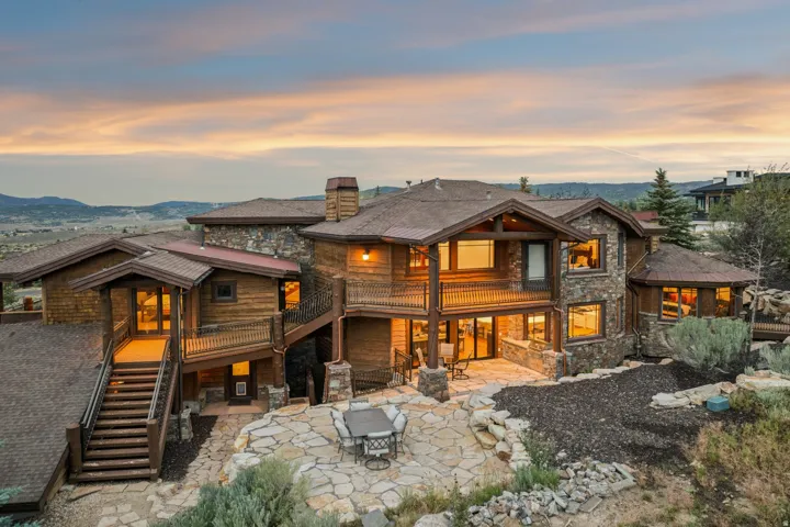 Expansive multi-level residence featuring stone and wood-paneled exterior