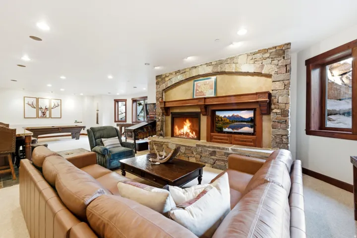Stone-accented fireplace with a wood mantle and built-in media center