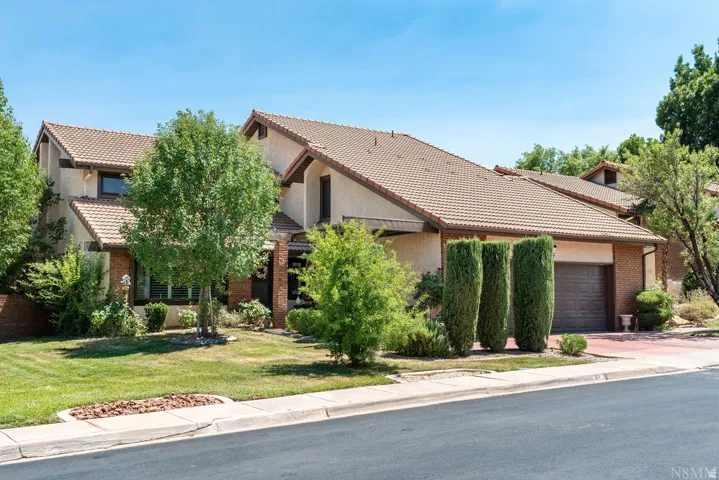 Southwestern-style residence featuring a tile roof and stucco facade
