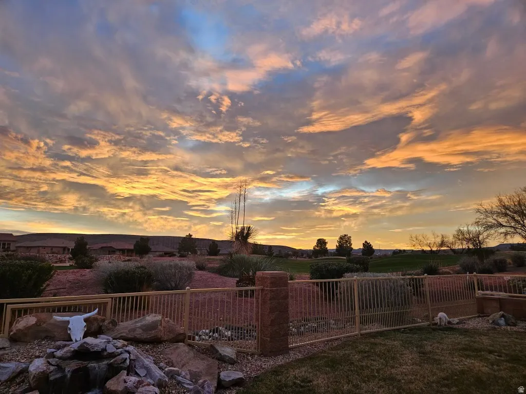 Expansive outdoor space featuring a rock garden, built-in water feature, and a perimeter fence with stone pillars