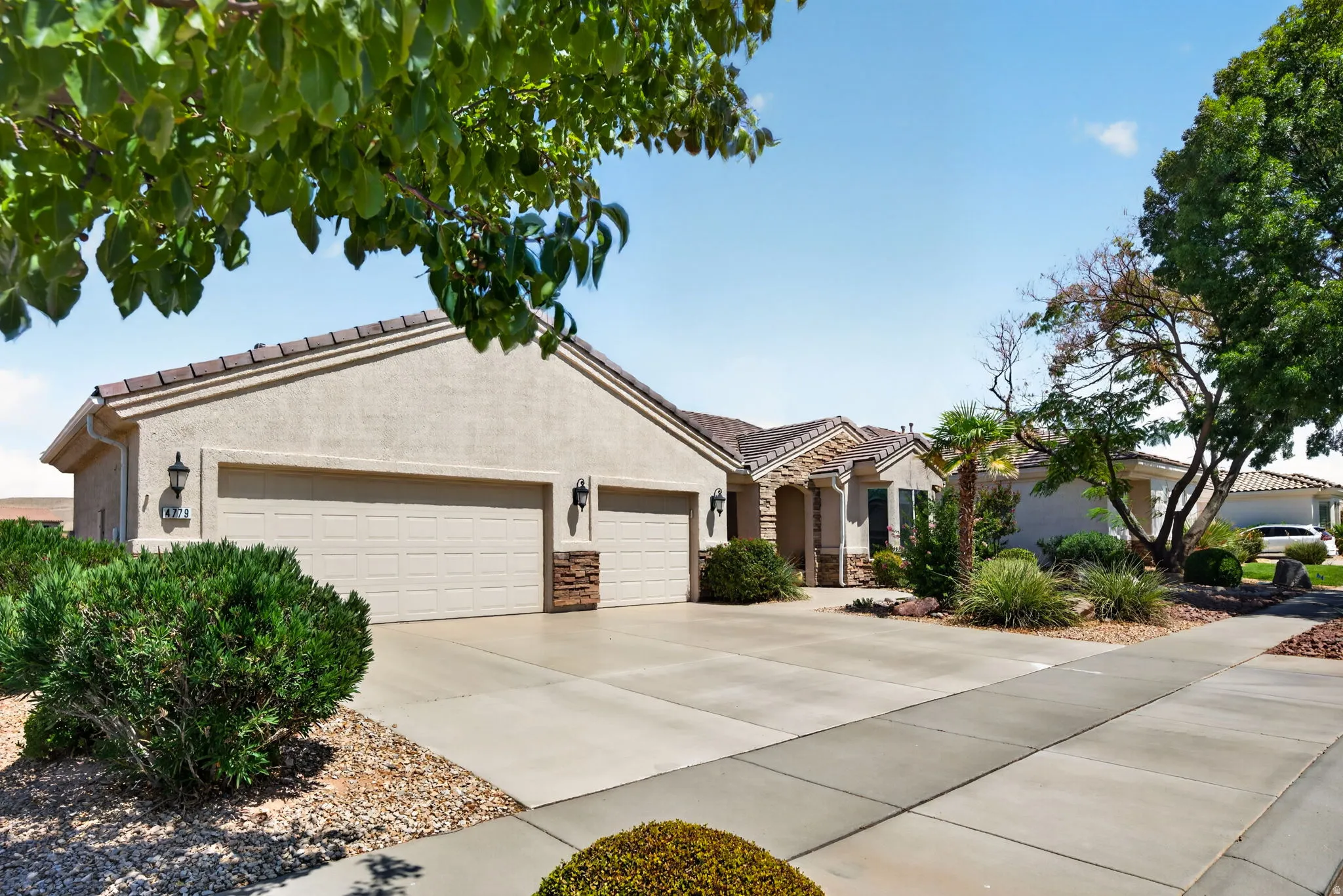 Stucco exterior with a tiled roof and a two-car garage