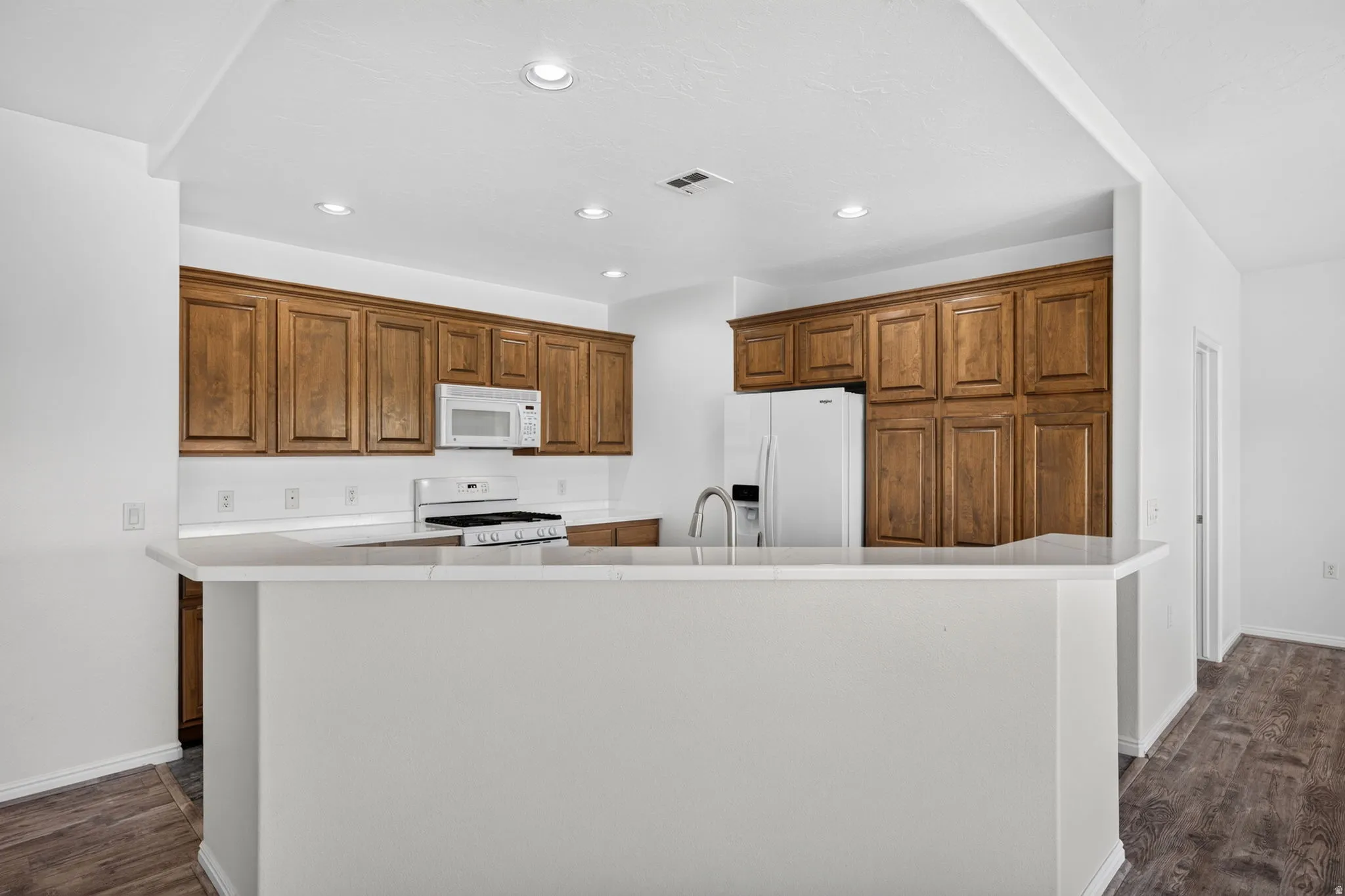 Kitchen featuring wood cabinetry, white countertops, white subway tile backsplash, and recessed lighting