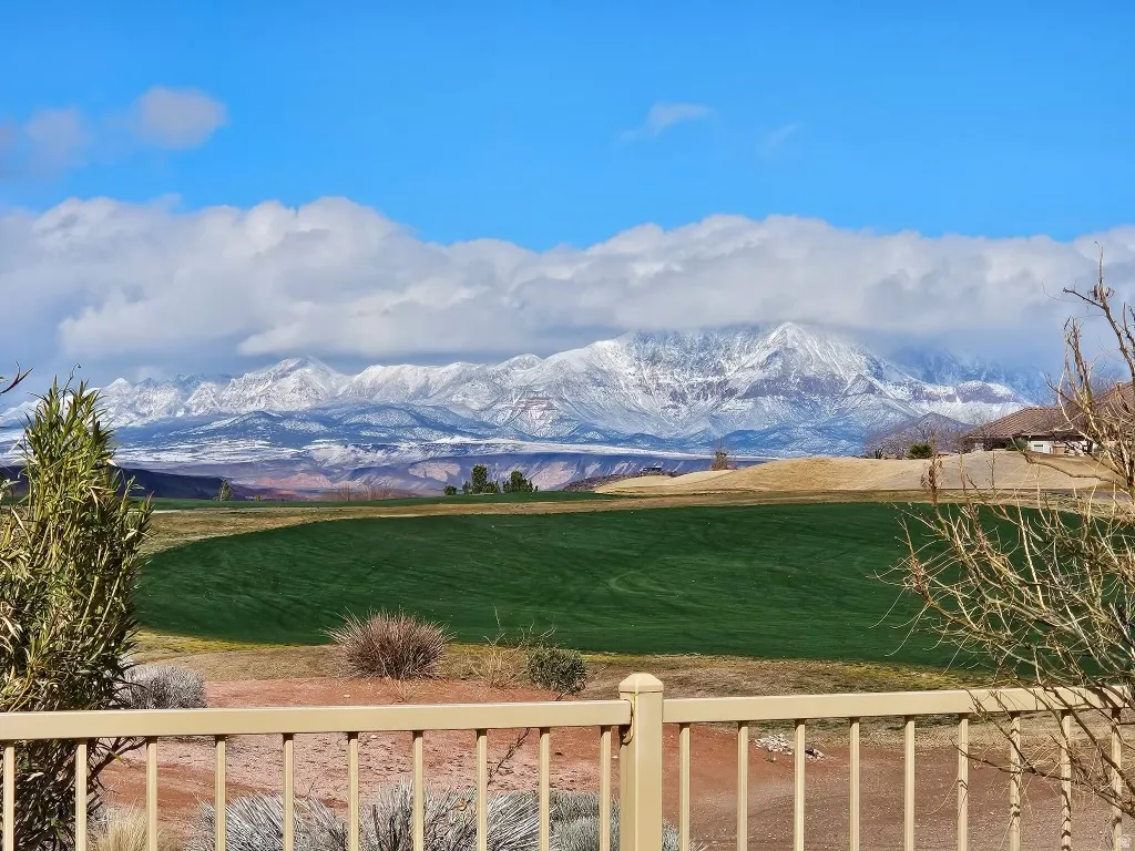 Expansive mountain backdrop featuring snow-capped peaks and a vibrant green field