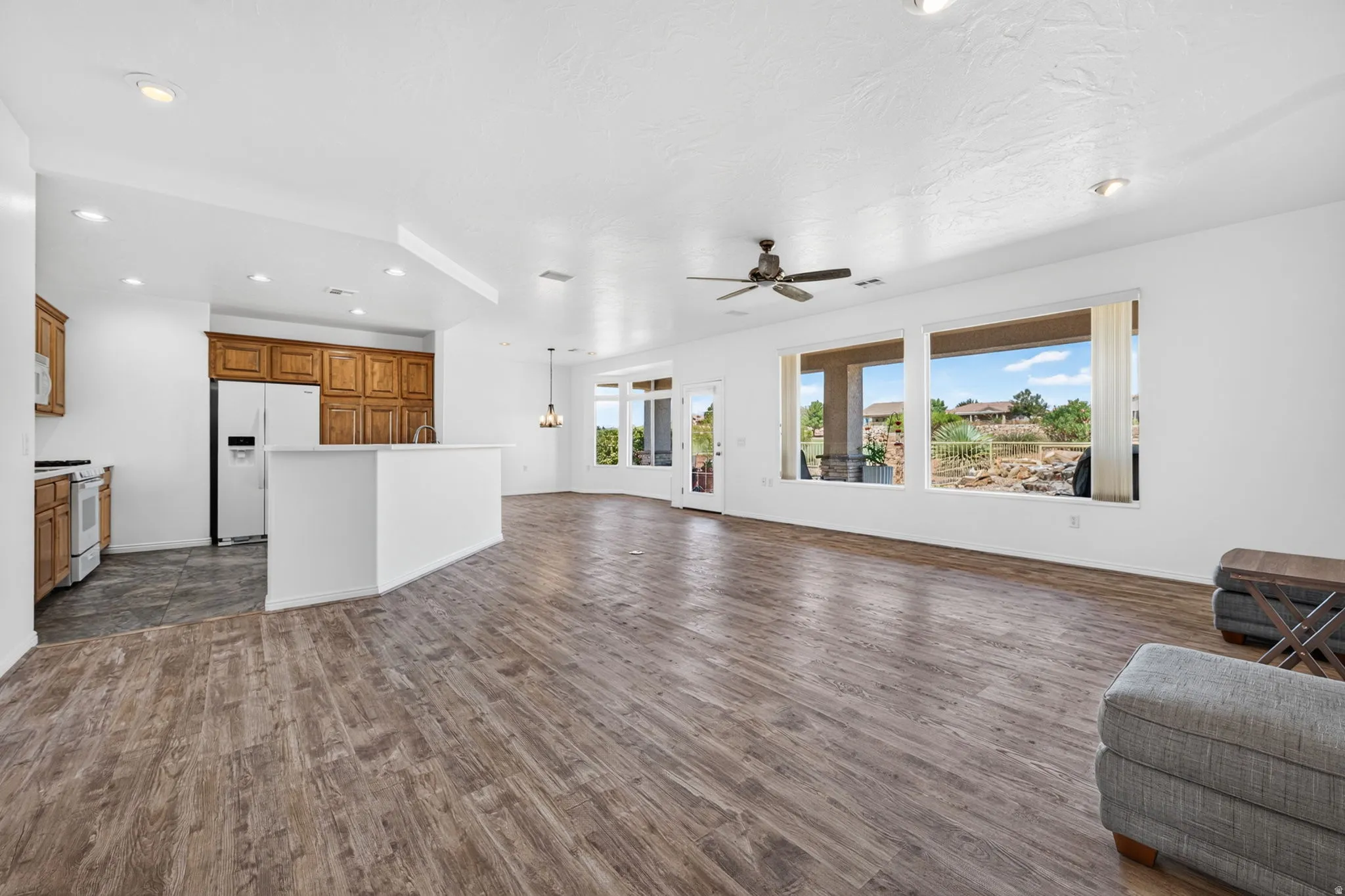 Open-concept living area featuring wood-finish flooring and multiple large windows