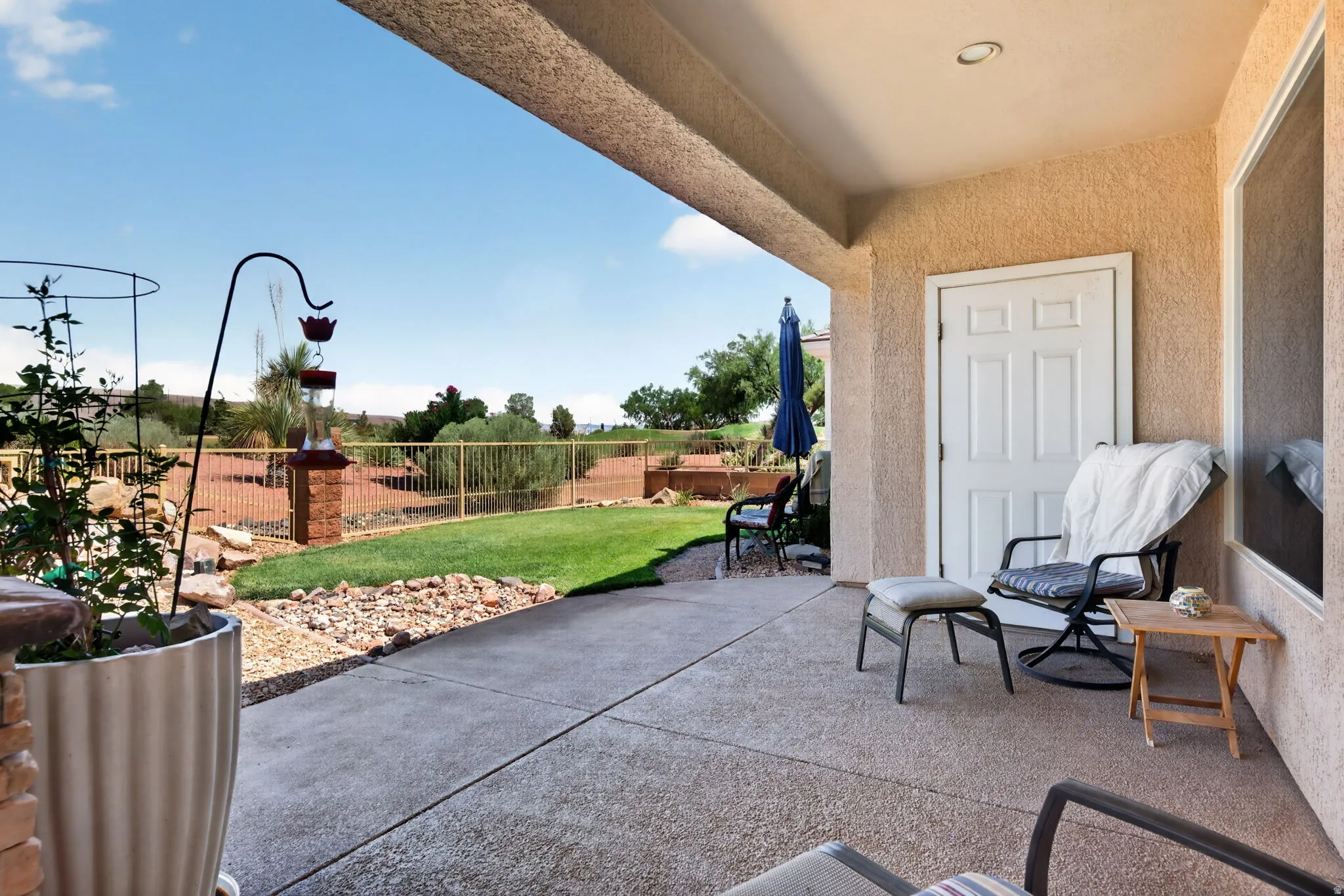 Covered patio featuring an exposed aggregate concrete surface, textured stucco walls, and a recessed ceiling light