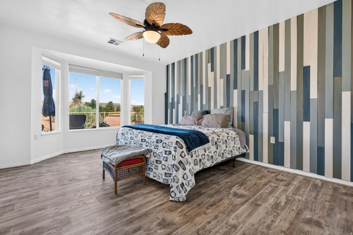 Bedroom featuring a decorative accent wall with vertical wood paneling in varying tones of blue, gray, and white
