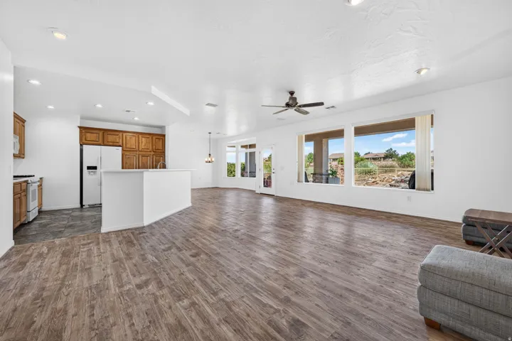 Open-concept living area featuring wood-finish flooring and multiple large windows
