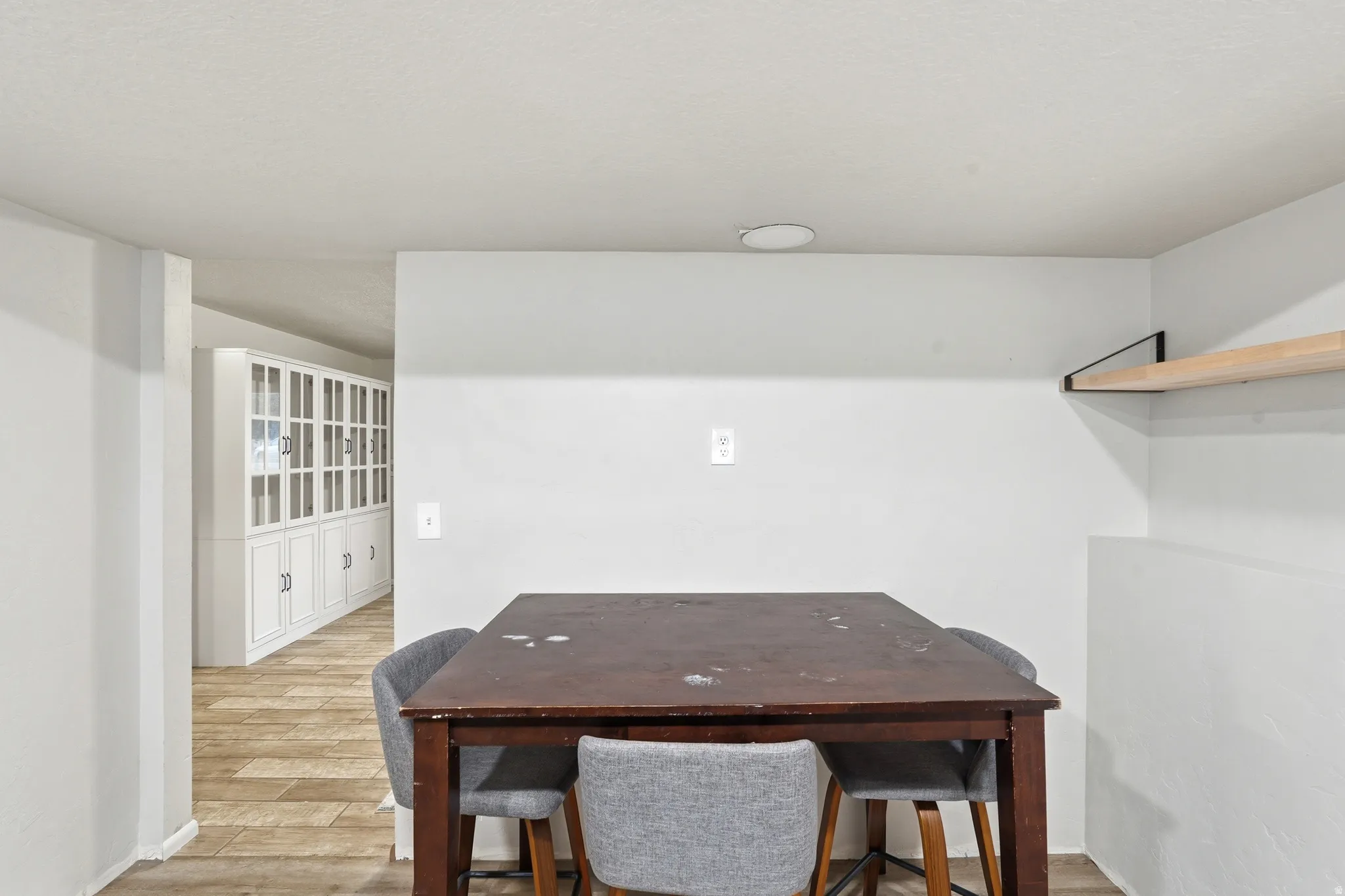 Built-in shelving with glass-fronted upper cabinets and solid lower cabinetry, offering extensive storage