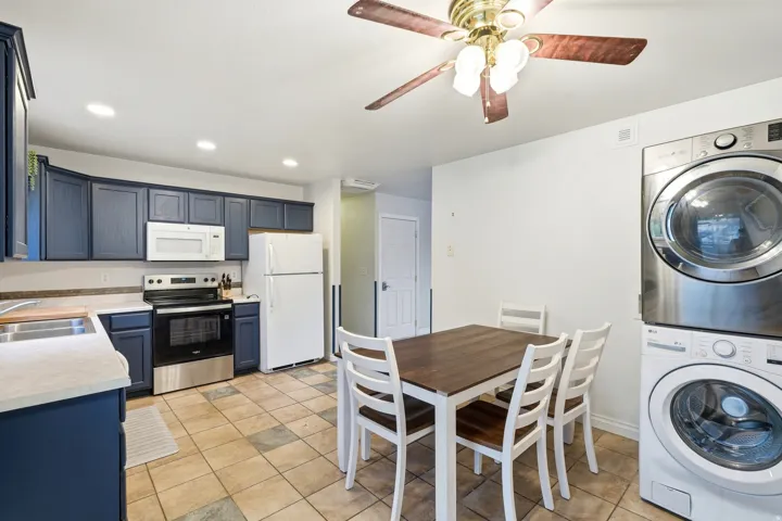 Kitchen featuring blue cabinetry, light-toned countertops, and a stainless steel oven
