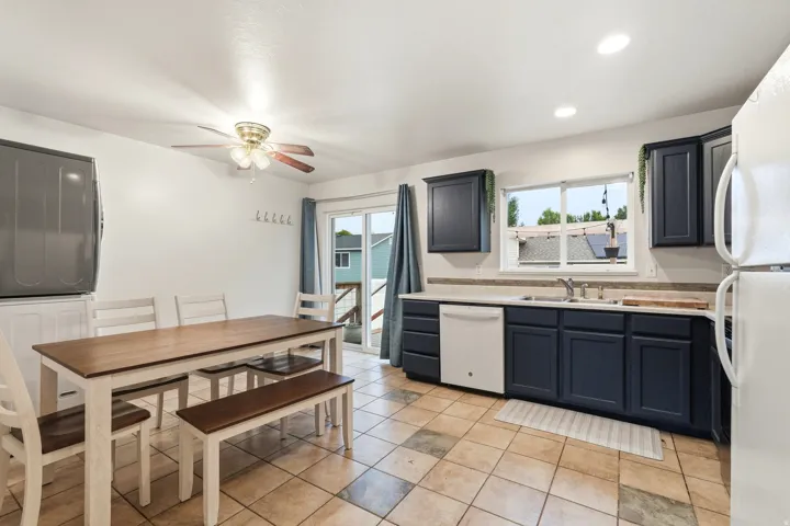 Kitchen featuring dark blue cabinetry, light countertops, and a white dishwasher