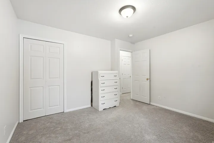 Neutral wall paint with textured ceiling, flush mount ceiling light, and gray carpet flooring