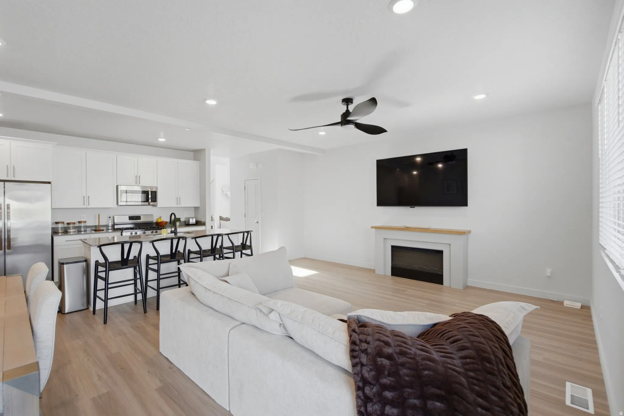 Open-concept living space featuring wood-finish flooring and recessed lighting