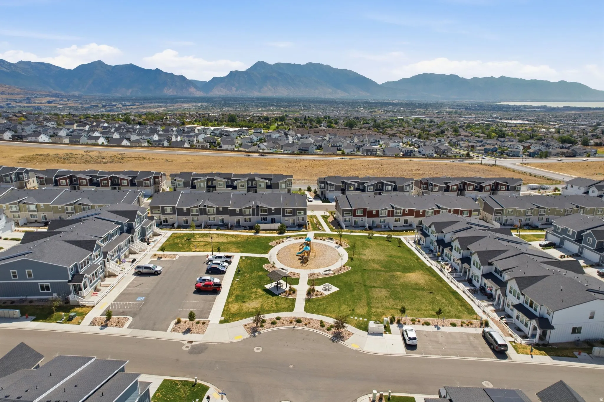 Community park with green space and playground equipment, surrounded by multi-story residential buildings