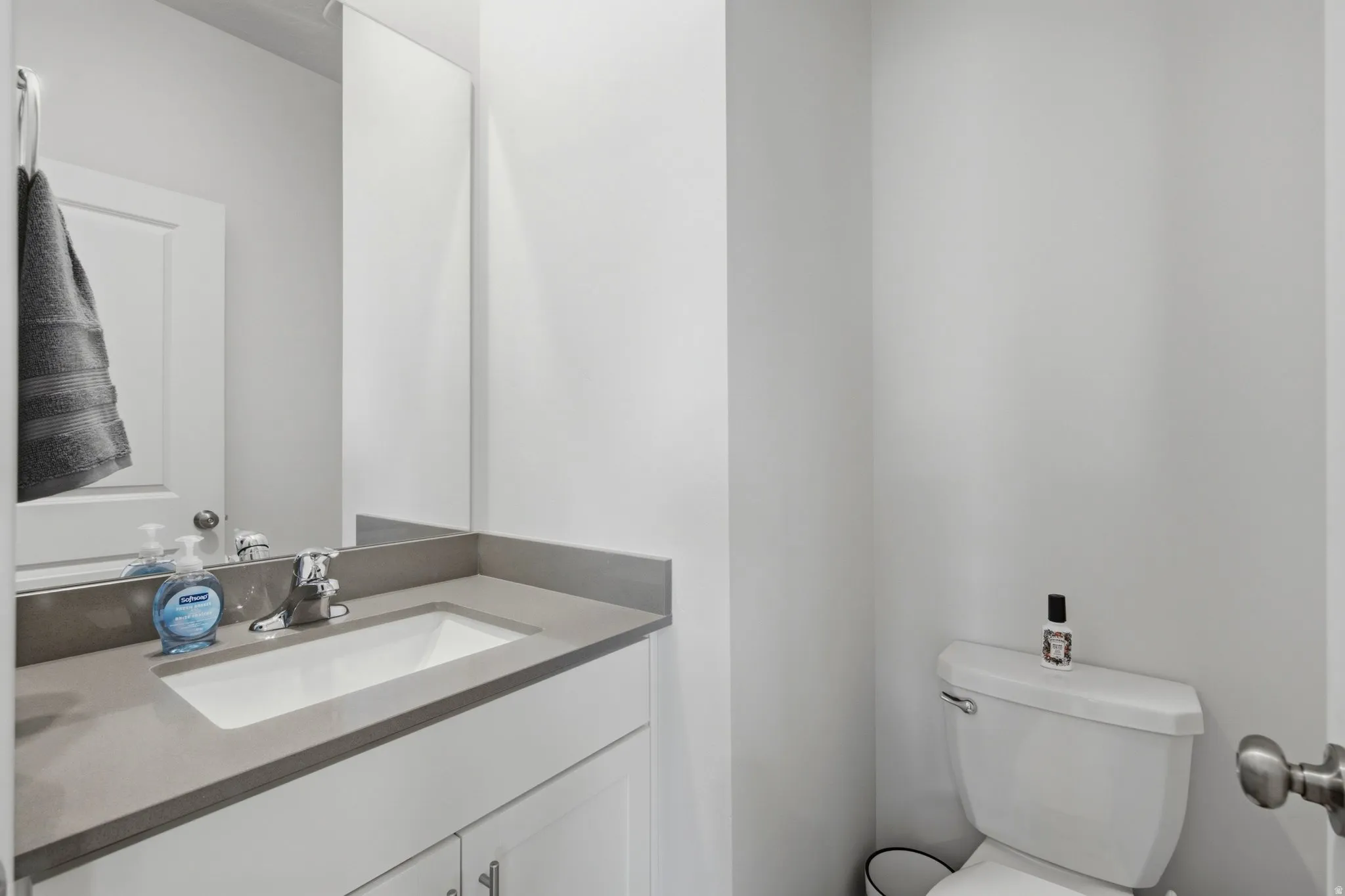 Vanity with a rectangular undermount sink, gray countertop, and chrome faucet
