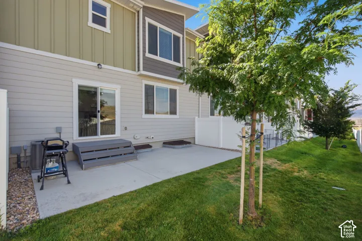 Rear patio with concrete surface, sliding glass door access, and composite deck steps