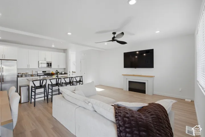 Open-concept living space featuring wood-finish flooring and recessed lighting