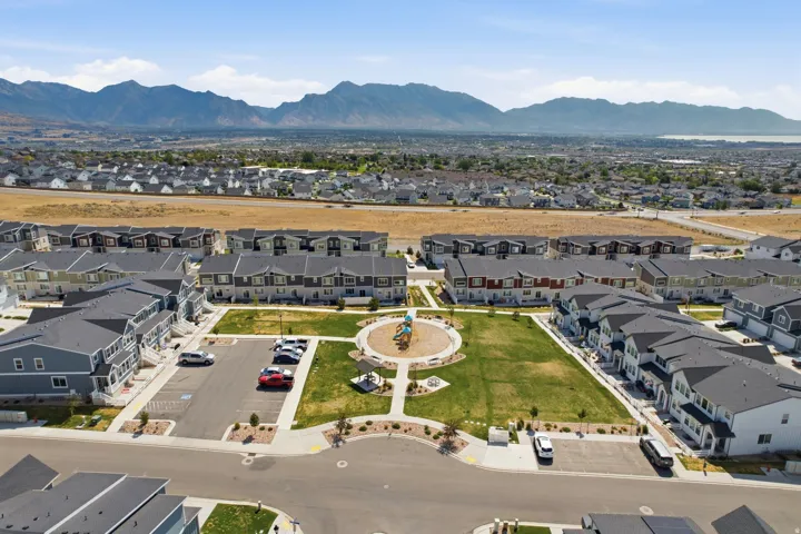 Community park with green space and playground equipment, surrounded by multi-story residential buildings
