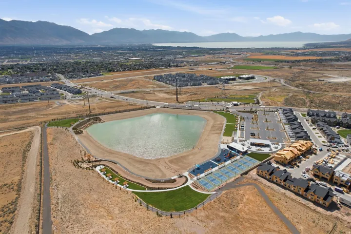 Aerial perspective showcasing a large residential community featuring a prominent central lake