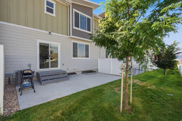 Rear patio with concrete surface, sliding glass door access, and composite deck steps