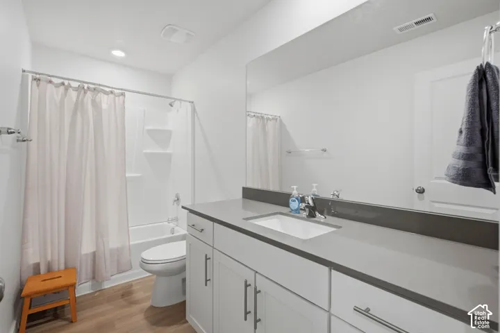 Bathroom featuring a single vanity with an integrated sink, a gray countertop, and white cabinetry