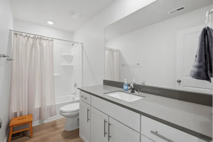 Bathroom featuring a single vanity with an integrated sink, a gray countertop, and white cabinetry