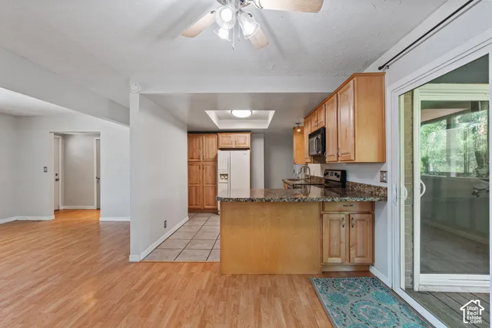 Kitchen featuring wood cabinetry, dark countertops, and stainless steel appliances