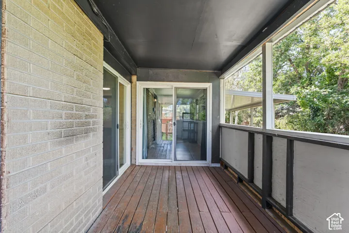 Screened porch featuring wood-finish flooring and a light-colored brick exterior wall