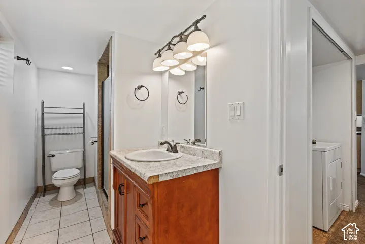 Bathroom featuring a single vanity with a laminate countertop, undermount sink, and dark bronze faucet