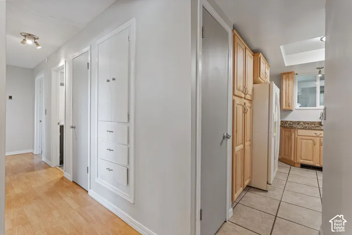 Hallway featuring wood-finish flooring and built-in storage cabinetry