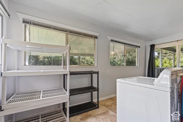 Utility room featuring multiple windows, a tiled floor, and light gray walls