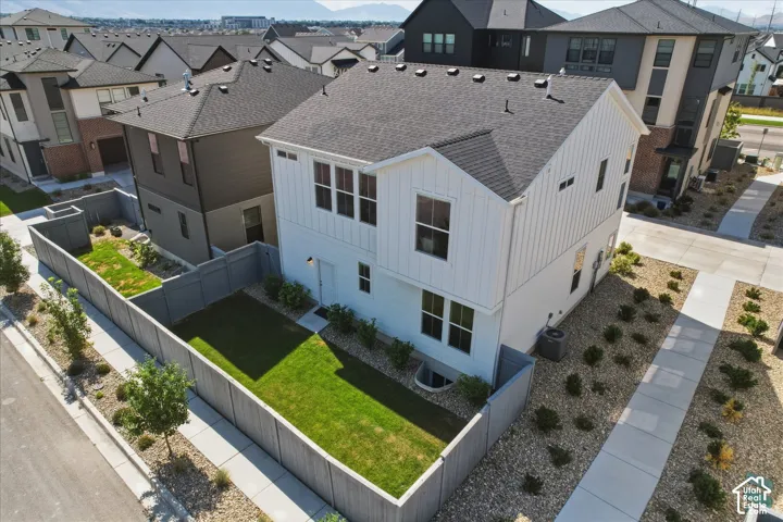 Contemporary two-story residence featuring white vertical siding and a dark shingle roof
