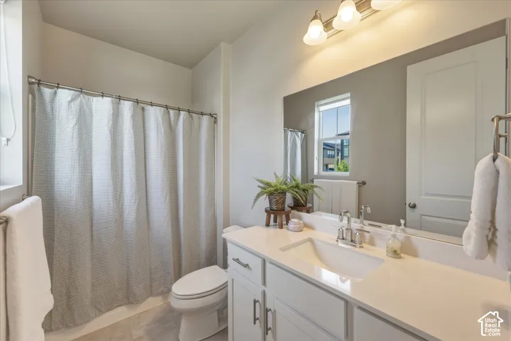 Bathroom featuring a single vanity with a white countertop, chrome faucet, and integrated sink