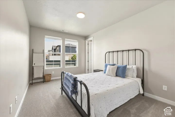 Carpeted bedroom with neutral wall tones and white trim