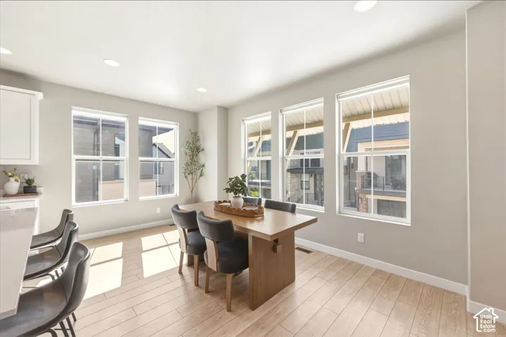 Open-concept dining area featuring light wood-finish flooring