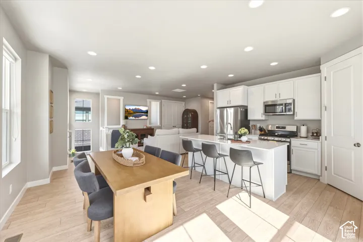 Open-concept living space featuring wood-finish flooring, recessed lighting, and white trim