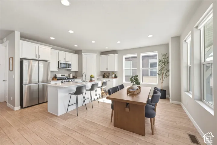 Modern kitchen and dining area featuring light wood-finish flooring