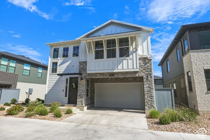 Modern elevation featuring vertical white siding and stone veneer accents