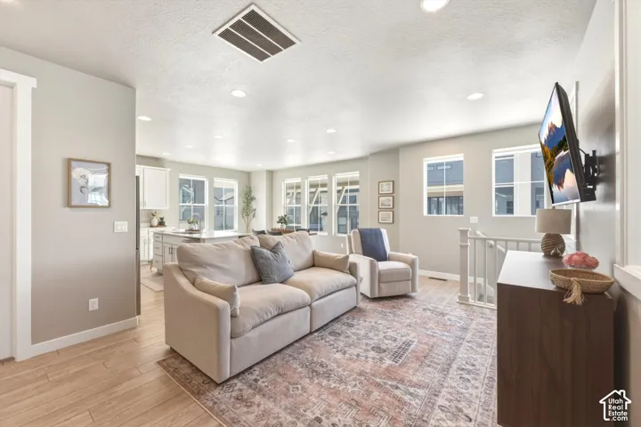 Open-concept living area with recessed lighting and light wood-finish flooring