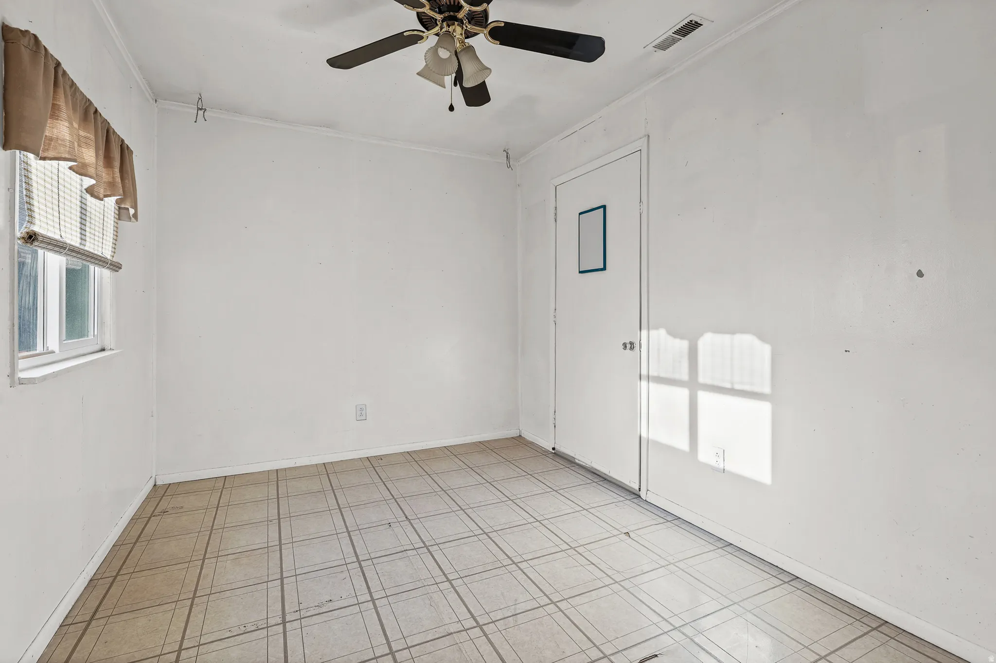 Wall-mounted ceiling fan, window with blinds, and tiled flooring