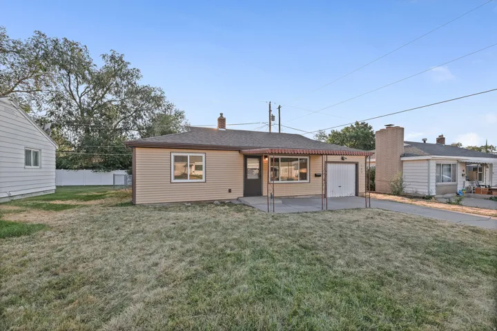 Single-story residence featuring light-colored siding, a covered front entry, and an attached garage with a white door